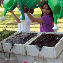At Inchelium Environmental Days, children examine the effects of different soil covers on run-off.
