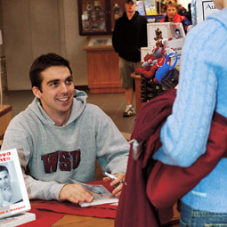 Recent grad Clint Borgen autographs copies of Geneva Nights in the Bookie. Shelly Hanks.
