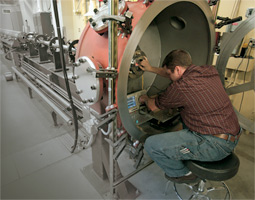 Bakeman reaches into the target chamber of the gun to prepare the diagnostic instruments.