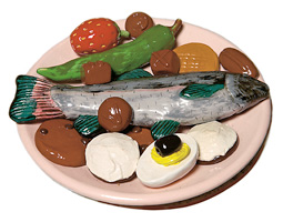 Ceramic plate with veggies, egg, and fish, by Marilyn Lysohir '79, from <em>Bad Manners</em> series.