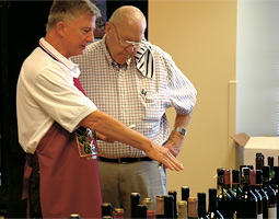Paul Hooper '53 (right) and another volunteer at the Northwest Enological Society's 2005 judging in Seattle discuss a round of wines being sampled by five expert judges.