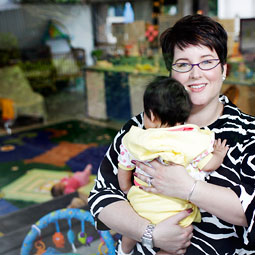 Alison Foliart takes a break from her administrative duties to visit with the young residents at Perinatal Treatment Services. Photo Rajah Bose.