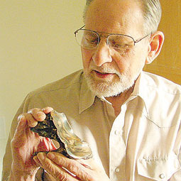 Carl Gustafson holds a mastodon tooth that was part of the 1977 discovery. <em>Courtesy Eric Sorensen</em>