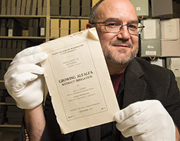 Archivist Mark O’English with the first WSC Extension bulletin, “Growing alfalfa without irrigation,” September 1913. <em>Robert Hubner</em> Archivist Mark O’English with the first WSC Extension bulletin, “Growing alfalfa without irrigation,” September 1913. <em>Robert Hubner</em>
