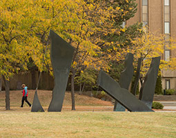 <em>Untitled</em> by Larry N. Tate (1977) is on the south side of Clark Hall. It is a silicon bronze sculpture with a ferric-nitrate patina. Photo Shelly Hanks