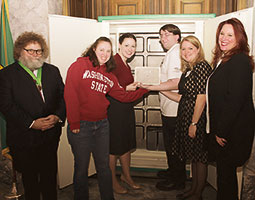 From left: Centennial Time Capsule Project mastermind Knute Berger, Kim Berlin ’03, Jennifer Estroff ’03, Eric Meadows, Jessica Gordon, and Secretary of State Kim Wyman place the 2014 container. <em>Courtesy Washington Secretary of State</em> From left: Centennial Time Capsule Project mastermind Knute Berger, Kim Berlin ’03, Jennifer Estroff ’03, Eric Meadows, Jessica Gordon, and Secretary of State Kim Wyman place the 2014 container. <em>Courtesy Washington Secretary of State</em>