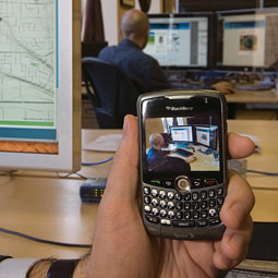 Orest Piskalns uses his BlackBerry to photograph co-worker Kevin Karpenske ’08 and show how MapWith.Us technology works. He uploads an image and then, using the phone’s Global Positioning System coordinates, pinpoints Karpenske’s location.