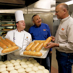 The Davenport Hotel in Spokane is one of many regional businesses that uses Shepherd's Grain flour, ground from wheat produced by the Shepherd's Grain cooperative, founded by Karl Kupers '71 (center) and Fred Fleming '73 (right), here with Davenport executive banquet chef Bryan Franz. Photo Shane Young.